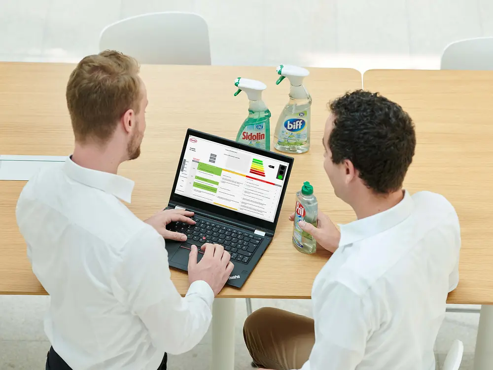 Двоє працівників компанії «Хенкель» із ноутбуком, на якому встановлено інструмент для визначення можливості переробки
