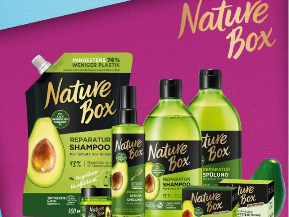Зелені пляшки продуктів Nature Box на рожевому фоні