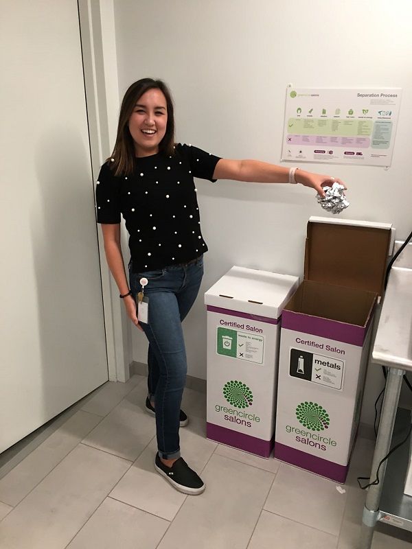 A Henkel employee demonstrates how to properly recycle salon waste using the various bins provided by Green Circle Salons.